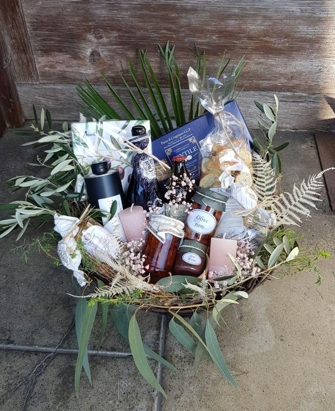 Dekorierter Geschenkkorb mit hochwertigen Lebensmitteln und Blumen